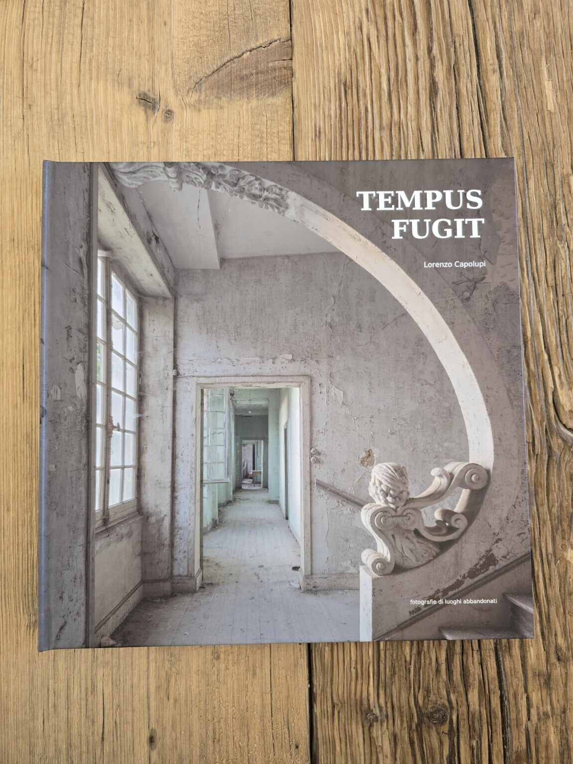 Il volume fotografico Tempus Fugit appoggiato sul tavolo in legno della Capolupi Factory